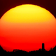 The sun sets behind a smokestack in Kansas City.